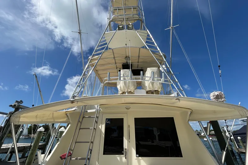 Slide: The Image of 1989 Hatteras 45 Convertible yacht with tower, docked under clear blue sky. - 54