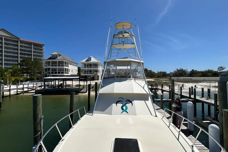 Slide: The Image of 1989 Hatteras 45 Convertible yacht docked at marina with waterfront buildings. - 7