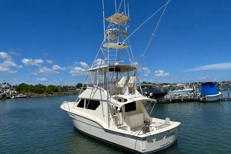 The Image of 1989 Hatteras 45 Convertible on the water, featuring a distinctive tower and clear blue sky backdrop. - 0