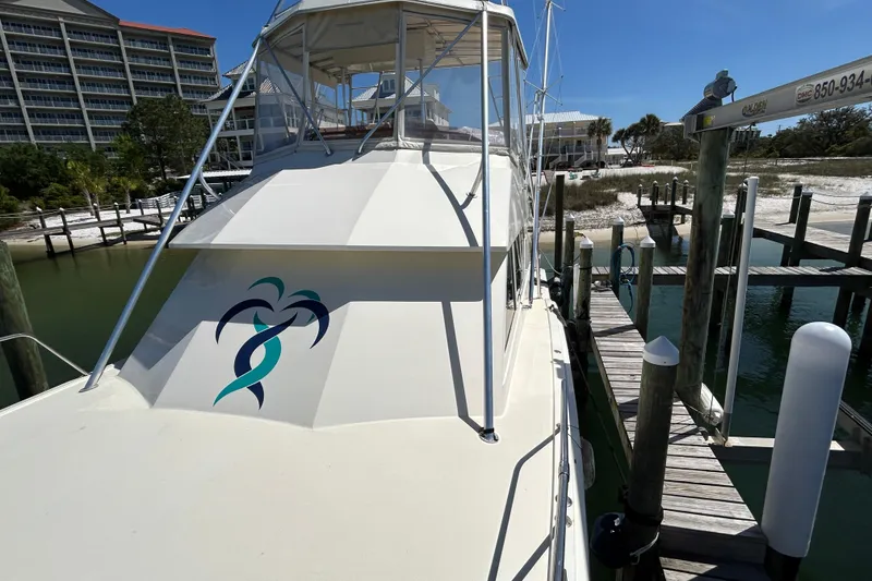 Slide: The Image of 1989 Hatteras 45 Convertible yacht docked at marina with palm tree graphic. - 9