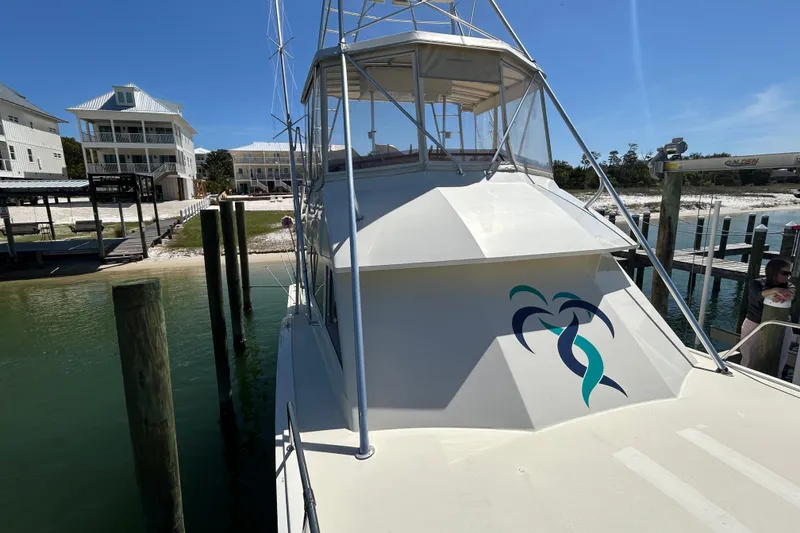 Slide: The Image of 1989 Hatteras 45 Convertible yacht docked, featuring a sleek design and vibrant logo. - 13
