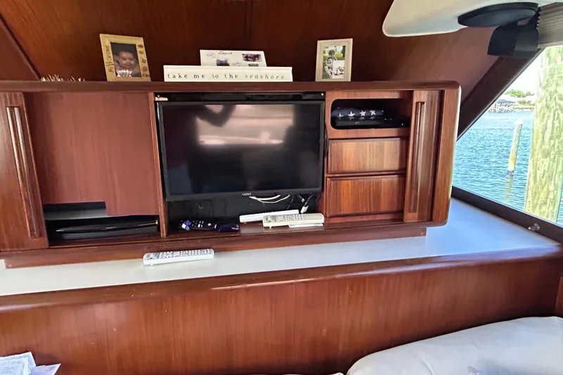 Slide: The Image of Interior of 1989 Hatteras 45 Convertible yacht with wooden cabinetry and a mounted TV. - 23