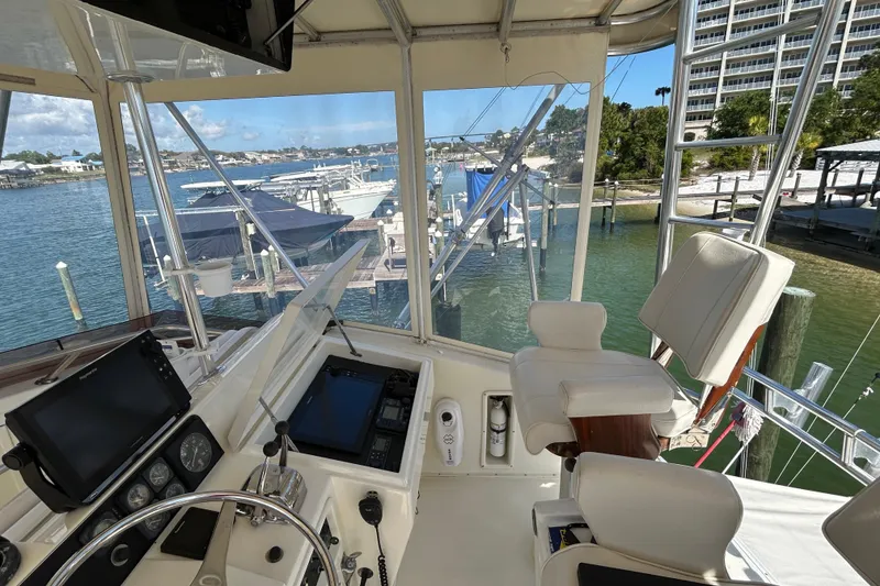 Slide: The Image of Helm of 1989 Hatteras 45 Convertible yacht with marina view. - 46