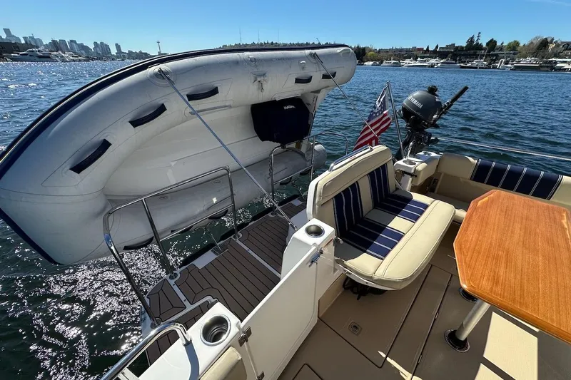 Slide: The Image of 2018 Ranger Tugs R-29 CB boat deck with seating, table, and mounted dinghy. - 15