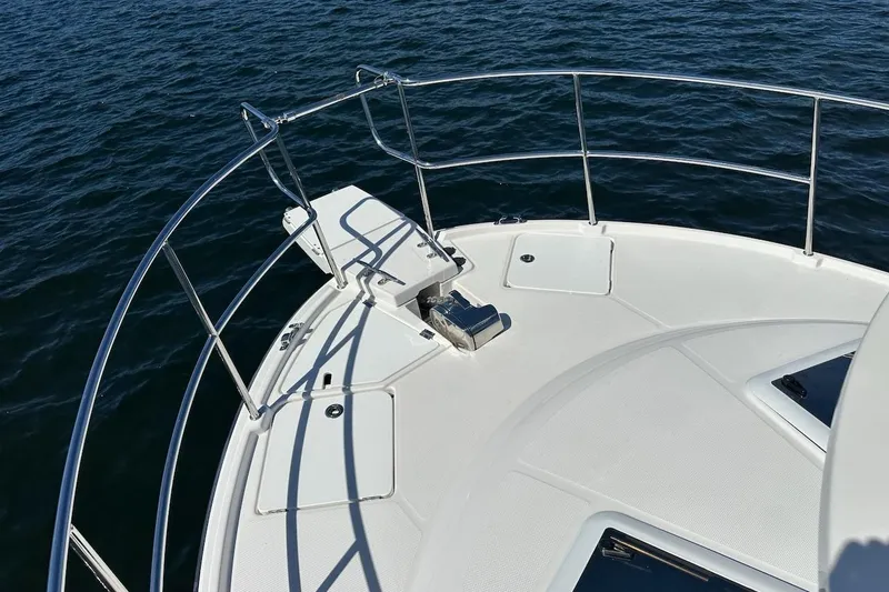 Slide: The Image of Bow of 2018 Ranger Tugs R-29 CB boat with railing and anchor, on water. - 17