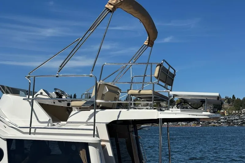 Slide: The Image of 2018 Ranger Tugs R-29 CB boat with upper deck seating on a sunny day. - 18