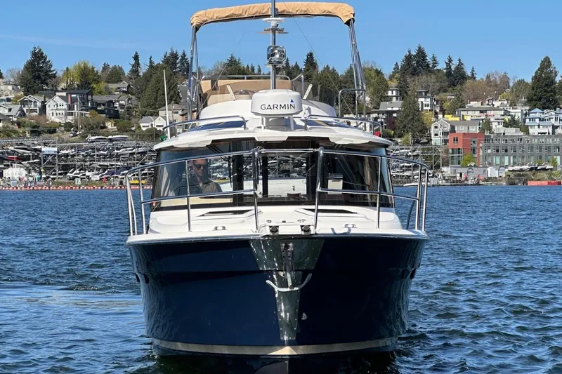 Slide: The Image of 2018 Ranger Tugs R-29 CB boat on water, with scenic waterfront background. - 2
