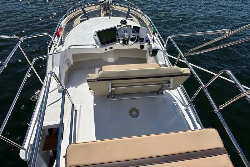 Slide: The Image of 2018 Ranger Tugs R-29 CB boat helm with seating, overlooking calm water. - 21