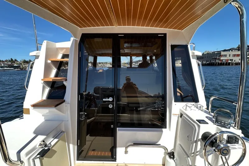 Slide: The Image of 2018 Ranger Tugs R-29 CB boat interior with wooden accents and waterfront view. - 27