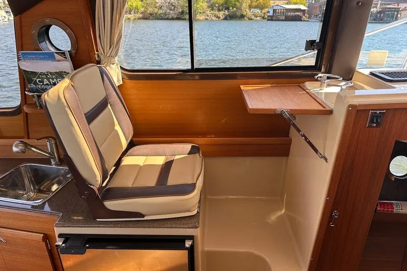 Slide: The Image of Interior of 2018 Ranger Tugs R-29 CB with seating, sink, and window view. - 37