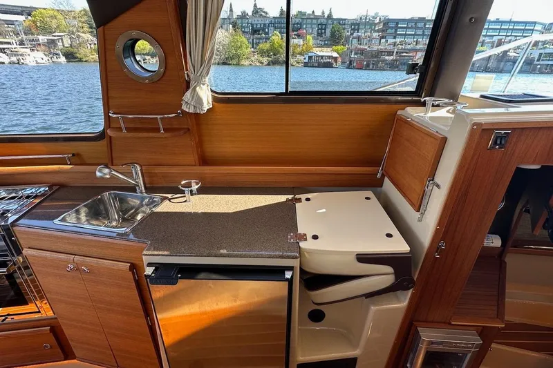 Slide: The Image of Interior of 2018 Ranger Tugs R-29 CB with kitchenette, sink, and wooden cabinetry. - 38