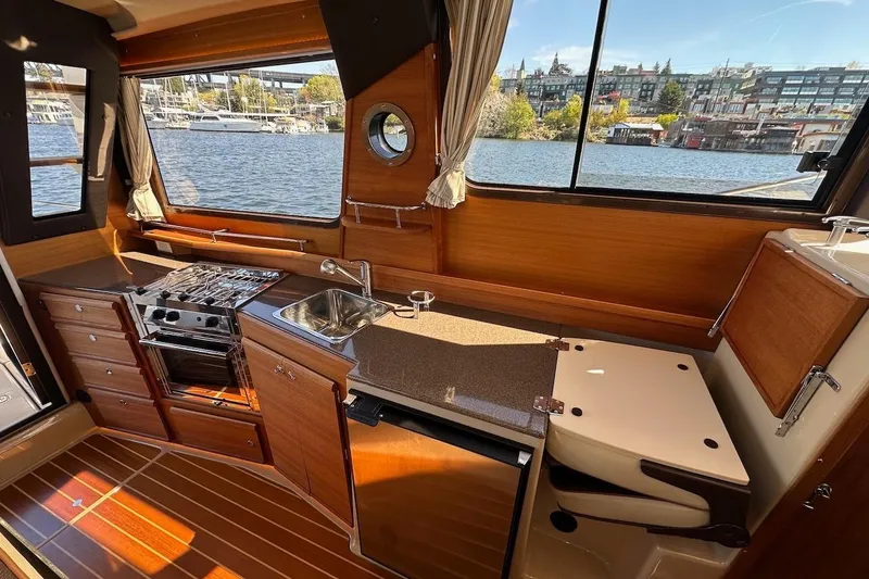 Slide: The Image of Interior of 2018 Ranger Tugs R-29 CB with kitchen, stove, and sink by waterfront. - 40