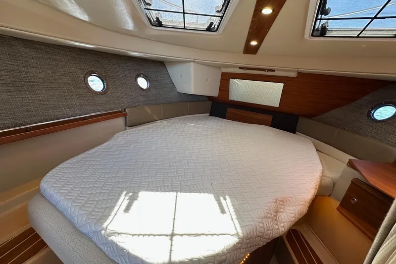 Slide: The Image of 2018 Ranger Tugs R-29 CB cabin interior with wood cabinetry and porthole windows. - 42