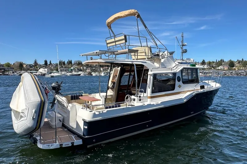 Slide: The Image of 2018 Ranger Tugs R-29 CB boat on water, featuring a spacious deck and modern design. - 8