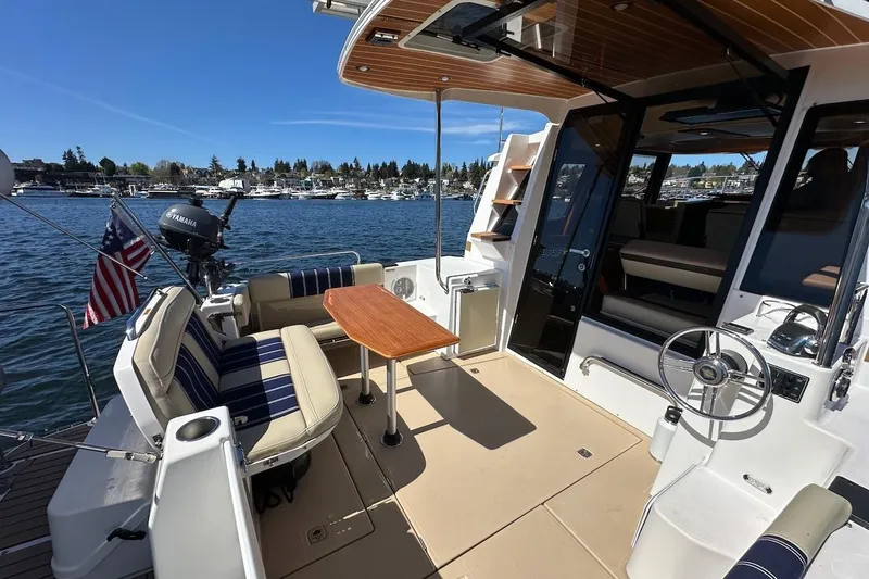 Slide: The Image of 2018 Ranger Tugs R-29 CB boat interior with seating and table on a sunny day. - 9