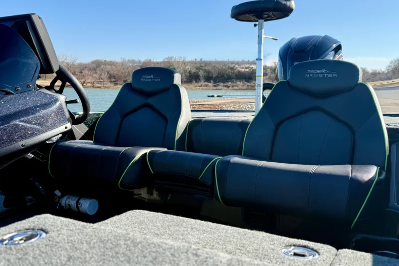 Slide: The Image of 2022 Skeeter ZX225 boat interior with dual seats, steering wheel, and lake view. - 10
