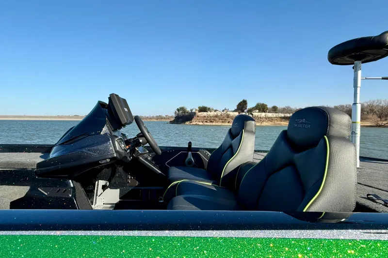Slide: The Image of 2022 Skeeter ZX225 boat interior with steering console, seats, and water view. - 11