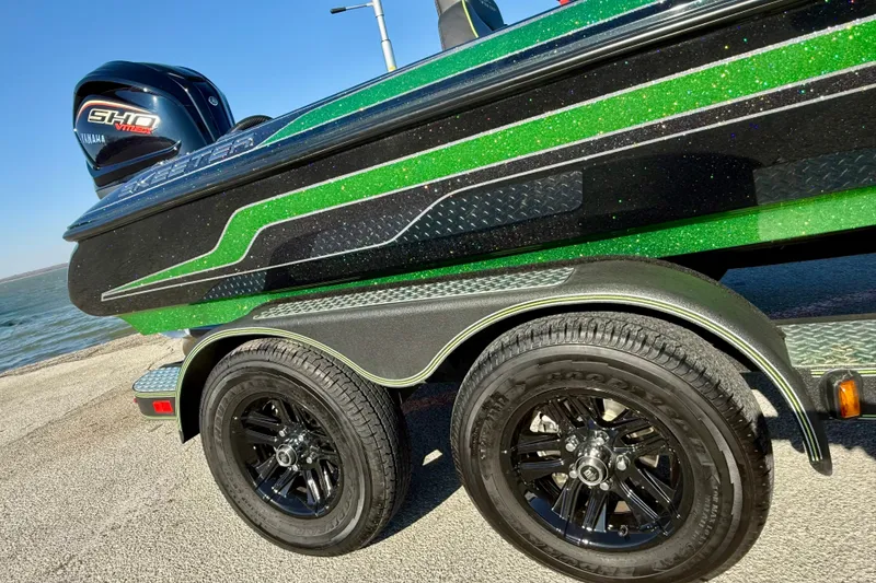 Slide: The Image of 2022 Skeeter ZX225 boat with green and black design, parked near water. - 12
