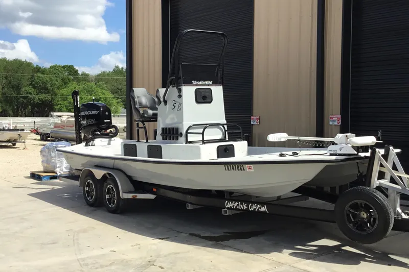 Slide: The Image of 2015 Shoalwater 23' Catamaran on trailer, parked outside a building. - 2