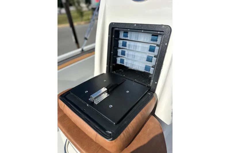 Slide: The Image of Open storage compartment on Avid 207 Recon boat, showcasing organized tackle boxes, 2026 model. - 18