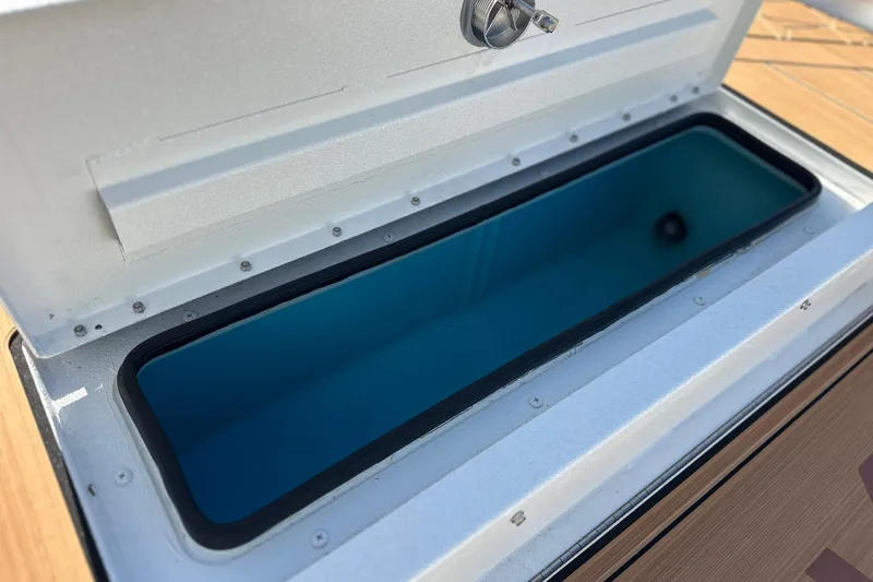 Slide: The Image of Open storage compartment on 2026 Avid 207 Recon boat, featuring a secure latch. - 28