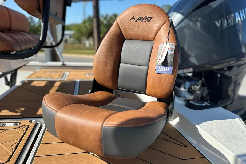Slide: The Image of Brown and black Avid 207 Recon boat seat, 2026 model, on deck with engine in background. - 6