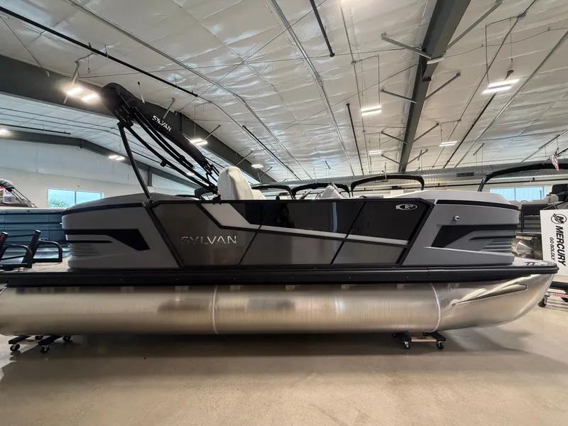 Slide: The Image of The image shows a 2027 Sylvan R-20 Q DH pontoon boat in a showroom. - 2