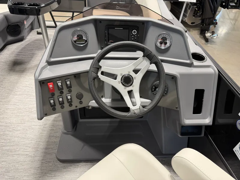 Slide: The Image of The image shows the helm of a 2027 Sylvan R-20 Q DH boat with a steering wheel and instruments. - 10