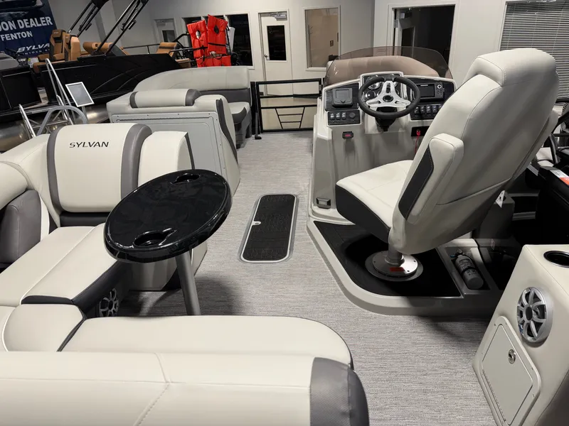 Slide: The Image of Interior of a 2026 Sylvan MIRAGE X3 DLZ BAR with luxurious seating and helm console. - 23