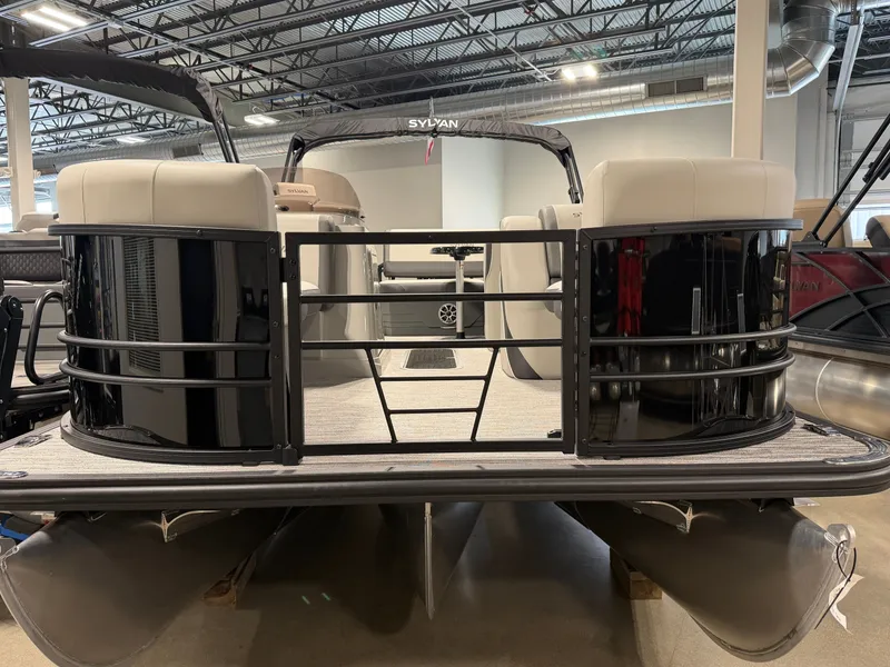 Slide: The Image of The image shows a Sylvan MIRAGE X3 DLZ BAR pontoon boat in a showroom. - 4