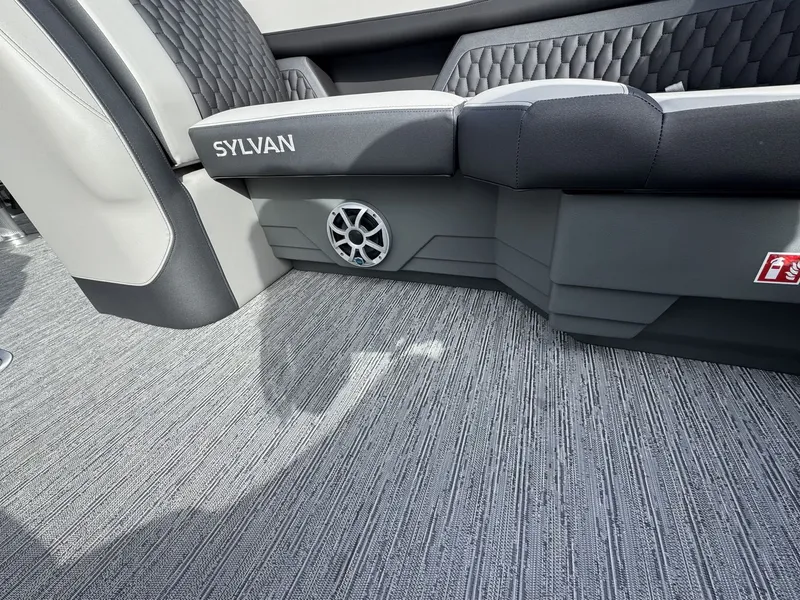 Slide: The Image of Interior of a 2026 Sylvan L3 DLZ with gray carpet flooring and cushioned seating. - 26