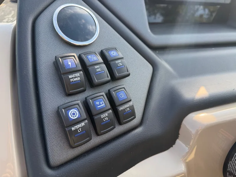 Slide: The Image of The image shows the dashboard of a Sylvan L3 DLZ boat with various switches. - 20
