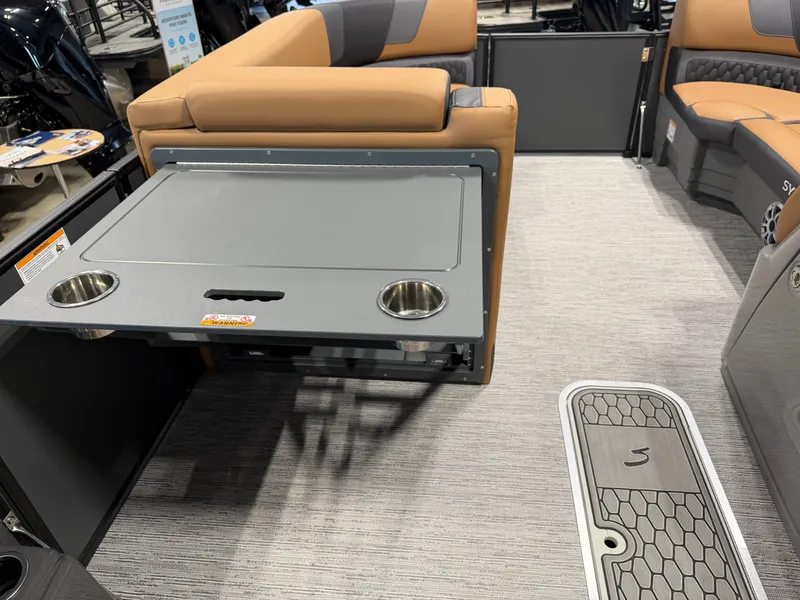 Slide: The Image of The image shows the interior of a 2026 Sylvan L3 DLZ boat with a fold-out table. - 22