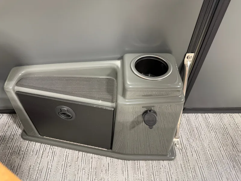 Slide: The Image of A gray boat console compartment with a cup holder and power outlet. - 20