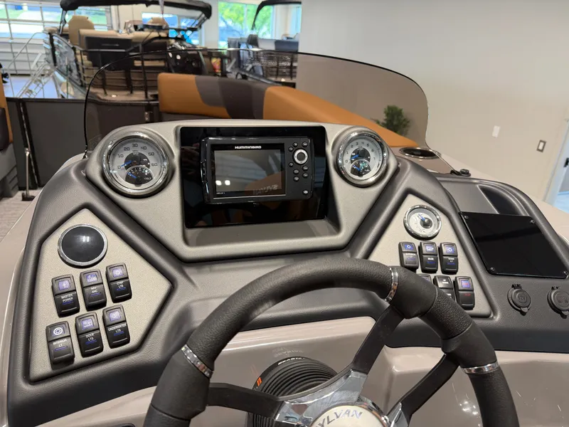 Slide: The Image of The image shows the helm of a 2026 Sylvan L3 DLZ boat with modern instruments. - 16