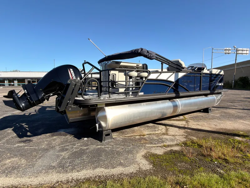 Slide: The Image of A 2026 Sylvan MIRAGE X3 DLZ BAR pontoon boat is parked on a lot. It features an outboard motor and a sunshade. - 5