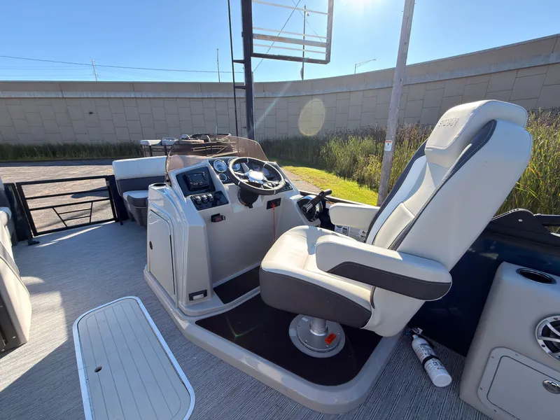 Slide: The Image of The image shows the helm of a 2026 Sylvan MIRAGE X3 DLZ BAR with a comfortable captain's chair. - 33