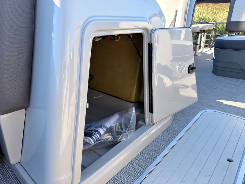 Slide: The Image of An open storage compartment on a 2026 Sylvan MIRAGE X3 DLZ BAR boat. - 27