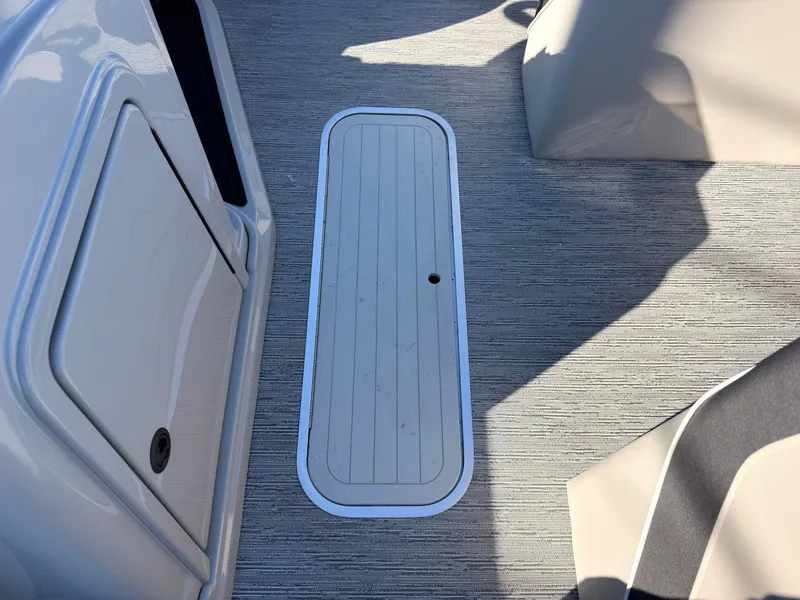Slide: The Image of Floor hatch on a boat with gray carpeting and white accents. - 28