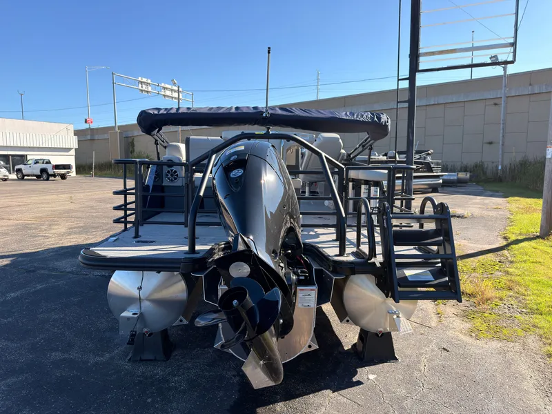 Slide: The Image of Sylvan MIRAGE X3 DLZ BAR 2026 with outboard motor, parked in a sunny lot. - 4
