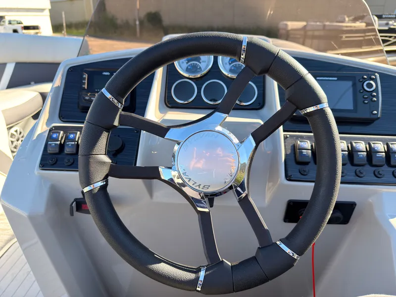 Slide: The Image of The image shows the helm of a Sylvan MIRAGE X3 DLZ BAR boat with modern instruments. - 45