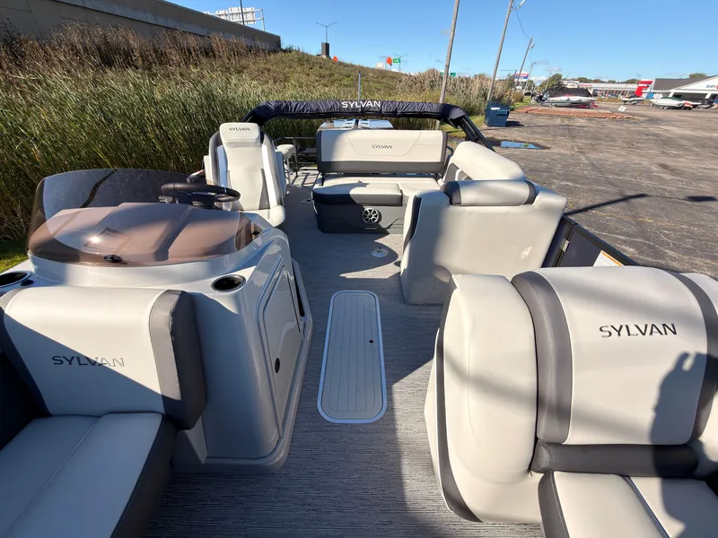 Slide: The Image of The image shows a Sylvan pontoon boat with gray seating and an open deck. - 25