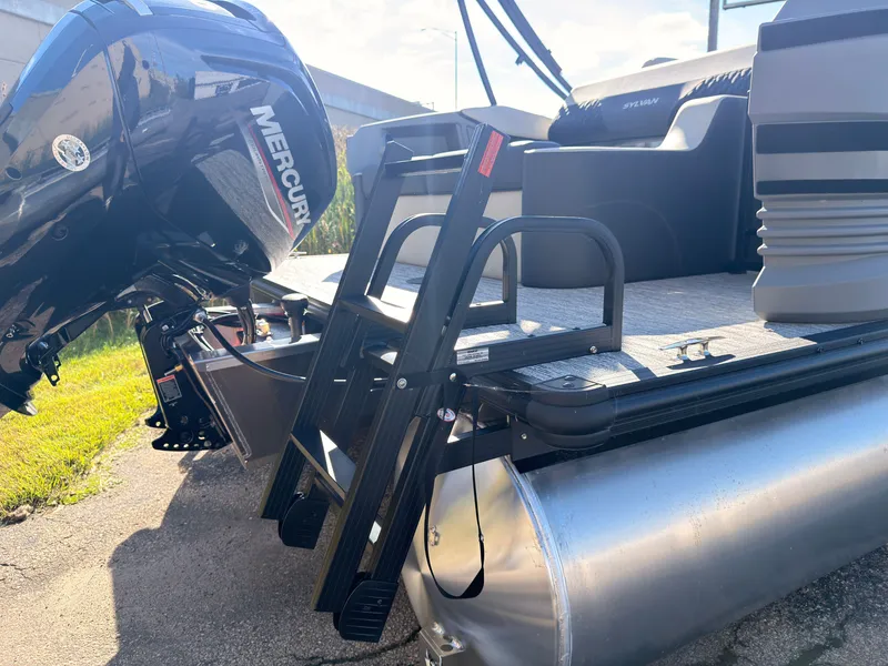 Slide: The Image of The image shows the rear of a 2027 Sylvan R-20 Q DH boat with a Mercury outboard motor and a black ladder. - 43