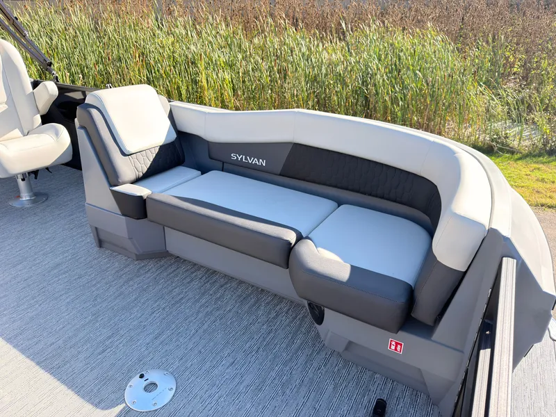 Slide: The Image of The image shows a modern seating area on a Sylvan boat, surrounded by reeds. - 9