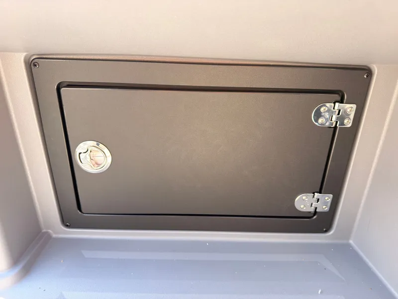 Slide: The Image of A closed storage compartment with metal hinges and a handle on a boat wall. - 36