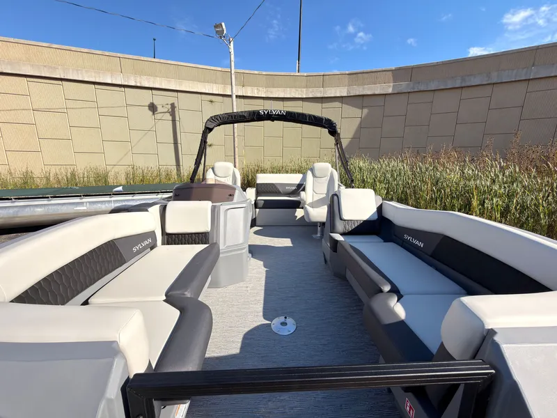Slide: The Image of The image shows a 2027 Sylvan R-20 Q DH pontoon boat with spacious seating and modern design. - 7