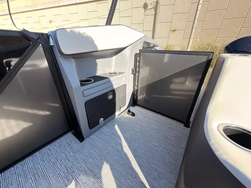 Slide: The Image of The image shows the interior of a 2027 Sylvan R-20 Q DH boat with storage and cup holders. - 39