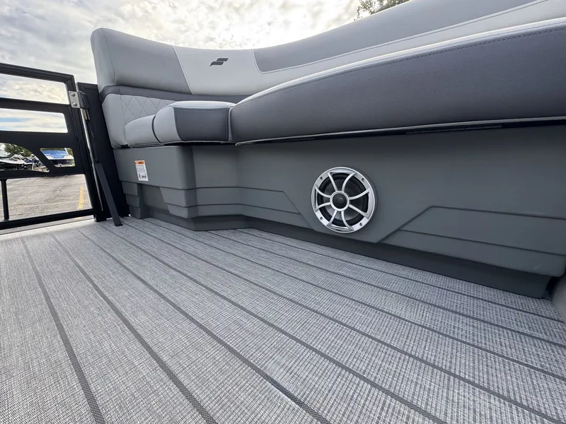 Slide: The Image of The image shows the gray interior of a Starcraft EXS 3 DL boat with cushioned seating and a speaker. - 27