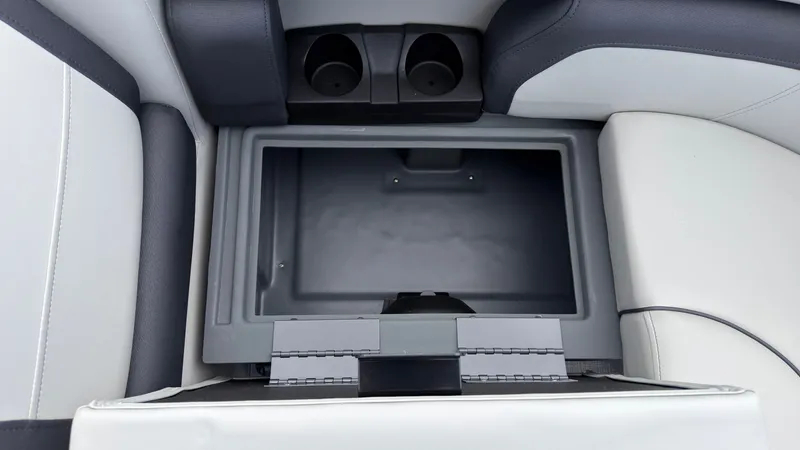 Slide: The Image of An open storage compartment with two cup holders in a boat. - 14