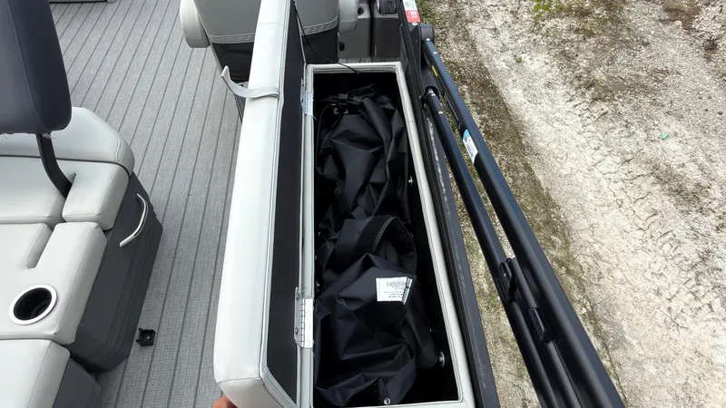 Slide: The Image of An open storage compartment on a boat with black covers inside. - 49